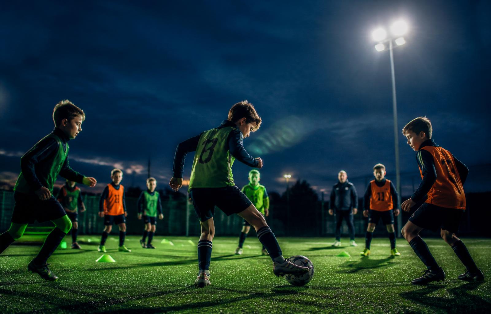 Kids training under floodlights at a midweek football session
